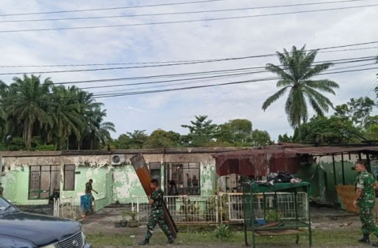 Warga dan prajurit TNI membersihkan puing-puing rumah yang terbakar di komplek Rindam I/BB, Pematangsiantar, Rabu (18/6/2025) pagi. Enam unit rumah hangus dalam peristiwa tersebut