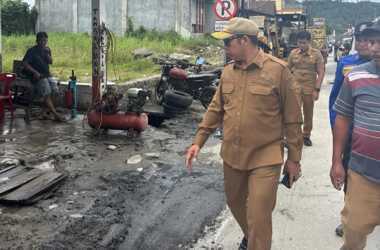 Bupati Taput, JTP Hutabarat, meninjau langsung pembersihan dan pengerukan  gorong - gorong di Jl DI Panjaitan, Tarutung. (Foto:istimewa)