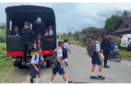 Personel Brimob Kompi 4 Batalyon C Polda Sumut mengantar pelajar SMP Negeri 4 Kota Gunungsitoli pulang sekolah dengan penuh kepedulian di wilayah Desa Fodo, Nias, Selasa (16/9/2025).