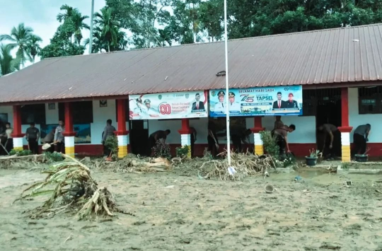Personel Batalyon C Pelopor Satbrimob Polda Sumut membersihkan fasilitas umum di SDN 100714 Garoga, Kecamatan Batang Toru