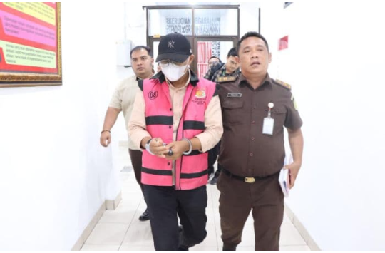 Petugas kejaksaan menggiring seorang pria berompi tahanan berwarna merah muda saat dibawa menuju ruang tahanan Kejari Medan.﻿(Foto: Dok. Kejari Medan)