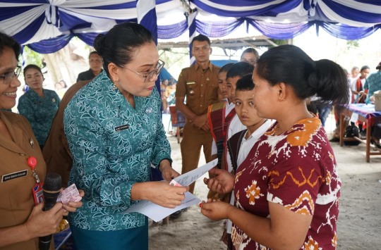 Ketua TP PKK Taput Ny. Neny Angelina JTP Hutabarat Br Purba saat menyerahkan bingkisan kepada lansia dan dokumen kependudukan kepada warga dalam kegiatan monitoring PHBS di Desa Aek Nauli 4, Sipahutar.