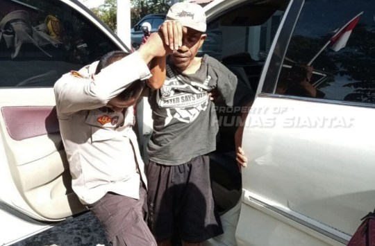 Bripka Asril Manurung, Bhabinkamtibmas Kelurahan Pematang Marihat, saat membantu seorang warga korban tabrak lari