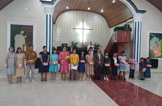 Pdt. Herbin Purba, S.Th., M.Th. (no.10 dari kiri) saat memberikan hadiah bagi warga jemaat HKBP Tapian Nauli, Minggu 20 Juli 2025