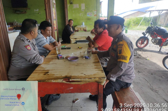 Kanit Binmas Polsek Dolok Silau, Aipda Waris Siswanto, bersama Bhabinkamtibmas, Bripka Perianto Sipayung, saat berkunjung ke warung milik Bapak Purba di Dusun Dolok Maraja, Nagori Saranpadang. (Foto: Humas Polres Simalungun)