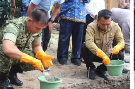 Letkol Inf Gede Agus Dian Pringgana saat meletakkan batu pertama pembangunan gerai pergudangan dan fasilitas  KMP di Huta VII Karang Anyar, Kecamatan Gunung Maligasi (foto: Pendim 0207/Sml)