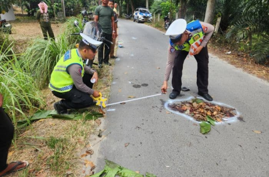 Petugas Sat Lantas Polres Simalungun melakukan olah tempat kejadian perkara (TKP) kecelakaan maut di Jalan Umum KM 7–8 jurusan Pematang Siantar–Panombeian Panei, Senin (10/11/2025).