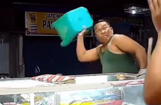 Pelaku saat melemparkan kursi dan balok ke arah korban