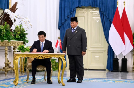 Didampingi Presiden Prabowo, Wang Huning mengisi buku tamu (foto; BPMI Setpres)