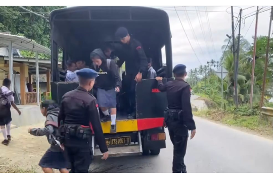 Personel Satuan Brimob Polda Sumatera Utara. Kompi 4 Batalyon C Sat Brimob Polda Sumut  mengantar anak seklah di NIas