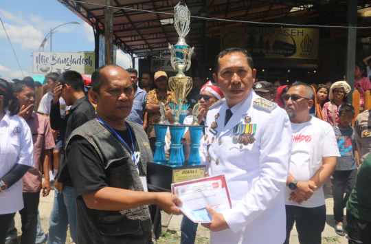 Bupati Tapanuli Utara Dr. Jonius Taripar Parsaoran Hutabarat menyerahkan hadiah kepada para juara lomba drum band pada perayaan HUT ke-80 RI yang digelar Tornado’s Club di Jalan Gerhard Lumbantobing, Tarutung.(Foto:Loksa Situmeang/Kabarnas.id)