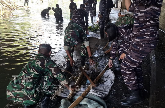 Tim Satgas Bencana Banjir Pangkalan TNI AL (Lanal) Denpasar membantu warga membersihkan sisa banjir. (foto : Dispen AL)